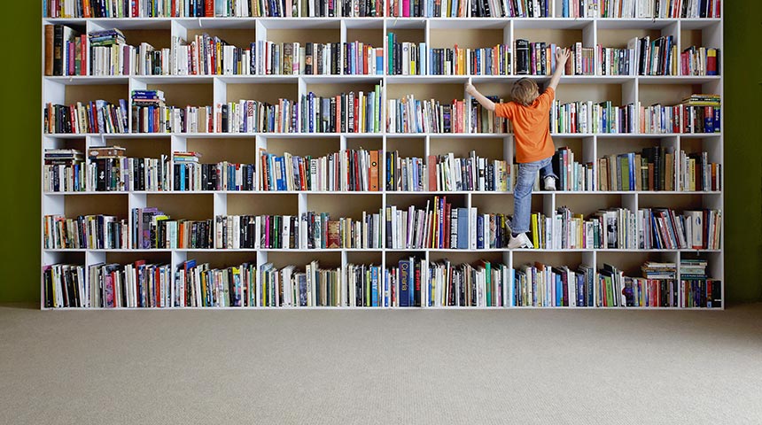 Child climbing onto book shelf
